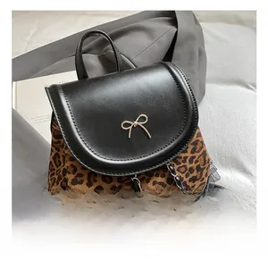 Détail de la texture léopard avec nœud doré et chaîne métallique sur le sac à dos