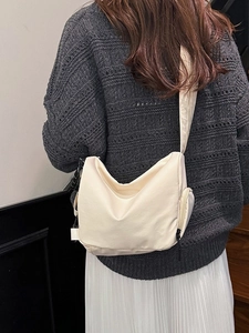Lightweight cream-colored outdoor backpack shown as a crossbody bag on a model