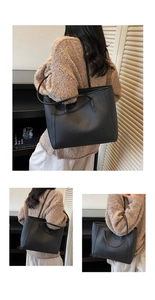 Detail of a black pebbled leather tote bag showing spacious design and dual shoulder straps