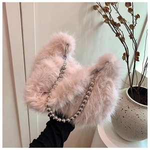Close-up of pink fluffy plush handbag featuring a silver metallic bead shoulder strap