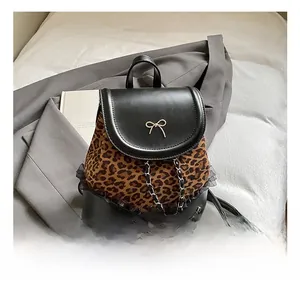 Détail d'un sac à dos léopard avec un nœud en métal et une décoration de chaîne chic