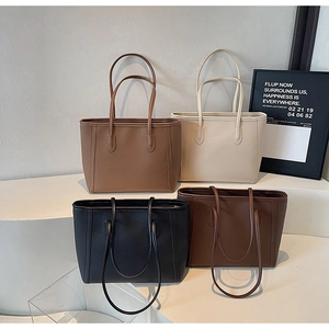 Litchi pattern leather tote bags in four neutral colors displayed on geometric tiers
