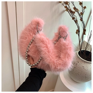 Close-up of pink fluffy faux fur handbag with stylish silver beaded handle detail