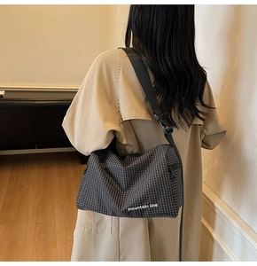 Detail of checkered canvas bag featuring mountain line print and adjustable strap