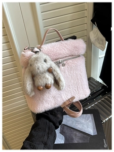 Détail du sac seau en peluche rose avec un pendentif lapin et fermeture zippée