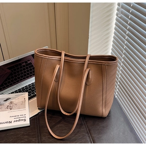 Macro view of brown lychee texture tote bag next to a laptop in an office setting