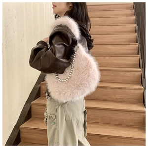 Detailed close-up of a plush pink faux fur hobo bag with a stylish silver beaded chain strap