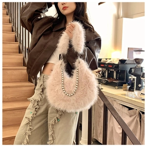 Detail of soft faux fur shoulder bag featuring decorative silver metal ball chain strap