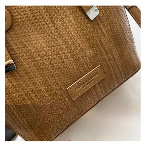 Close-up of brown woven leather texture with fashion metal hardware on bucket bag