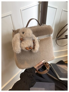 Détail d'un sac seau en peluche marron avec pendentif lapin et anse en cuir