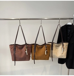 Three suede tote bags in brown, caramel and beige with ethnic bead pendants