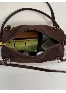 Vue intérieure montrant la grande capacité du sac boston en daim marron et finitions dorées