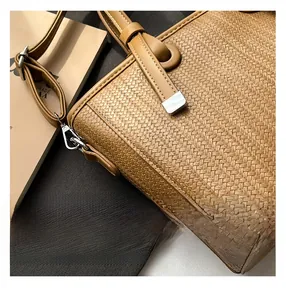 Close-up of brown cross-woven texture and silver metal buckle on a PU leather bucket bag