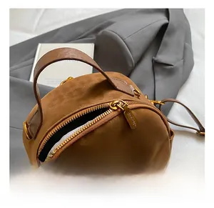 Detail view of premium golden metal hardware and smooth brown canvas material on backpack