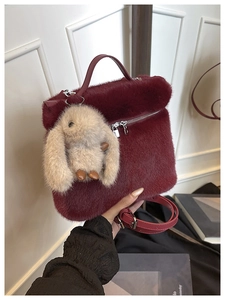 Détail du sac seau en peluche bordeaux avec pendentif lapin et bandoulière argentée