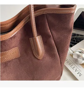 Detailansicht der dunkelbraunen Wildleder-Tote-Bag mit Lederpaspeln und Mode-Trend-Tag