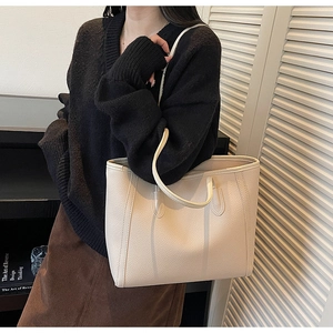 Detail of beige lychee pattern leather tote bag showing texture and shoulder strap