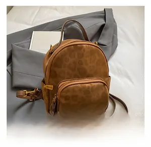 Detail view of mini leopard print backpack with gold zipper and textured suede material