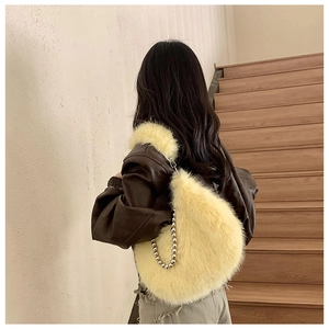 Detailed side view of fuzzy hobo bag with silver ball chain accessory and soft plush texture