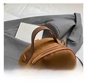 Detail view of the comfortable brown leather handle and golden hardware of the mini backpack