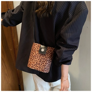 Detail of leopard print shoulder bag featuring suede texture and silver metal buckle