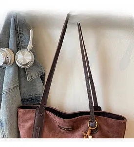 Detailed view of durable shoulder straps and textured suede fabric on the large tote bag