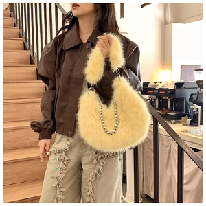 Close-up of a plush faux fur hobo bag in light yellow with decorative silver bead chain