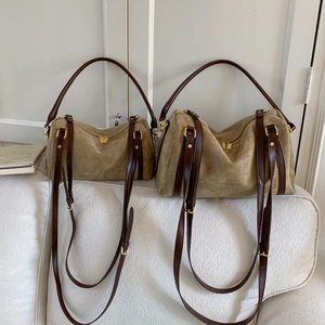 Vue détaillée de deux sacs cabas en daim kaki mat de tailles différentes sur un canapé