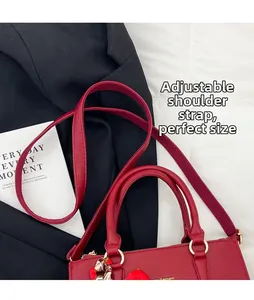 Detail of red pebbled leather tote featuring adjustable shoulder strap and printed silk scarf