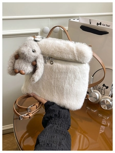 Détail du sac seau en peluche blanche avec texture en fausse fourrure et breloque lapin
