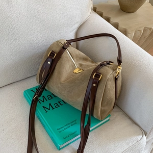 Détails de la texture du daim kaki et des lanières en cuir sur le sac Boston vintage