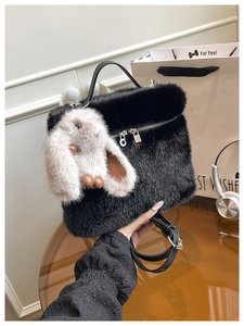 Détail du sac seau en peluche noire avec breloque lapin gris et ferrures en métal argenté