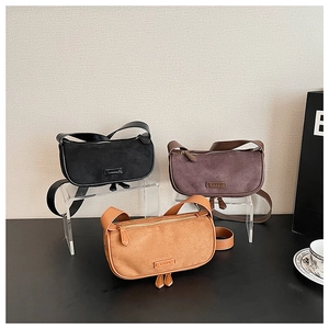 Detailed close-up of small vintage suede crescent bags in black, coffee, and tan colors