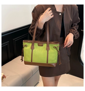 Detail view of avocado green suede tote bag with brown leather straps and drawstring