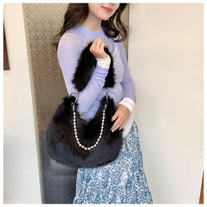 Detail of plush black faux fur handbag with silver bead chain and soft texture