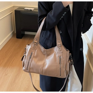 Close-up of litchi texture on khaki tote bag with dual metal zipper decorations