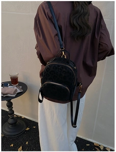 Chic black leopard print mini backpack shown in a lifestyle street style setting