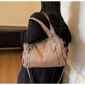 Detail view of khaki pebbled leather tote bag showing spacious design and side pockets