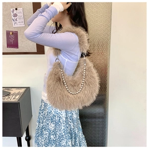 Detail of light brown fuzzy plush hobo bag featuring a decorative silver metal ball chain