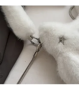Close-up of white plush fabric texture with silver star charm and metal chain hardware