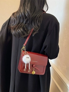 Vintage dark red crossbody bag in glossy leather with a cute monster plush pendant