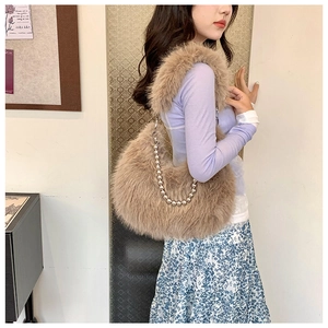 Detail of khaki faux fur crescent bag featuring stylish silver metal beaded chain strap