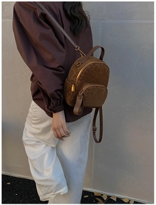 Detailed view of leopard print mini backpack with golden zipper on a model's back