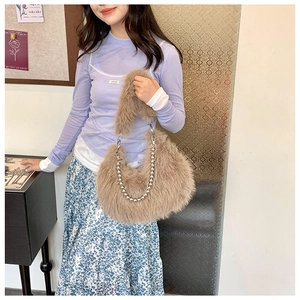Detail of plush faux fur shoulder bag with stylish silver beaded chain and soft handle