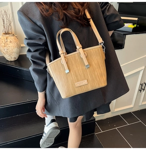 Lifestyle view of khaki woven tote bag showing its size and stylish crossbody fit