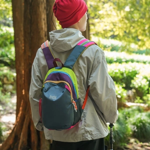 Outdoor model shot of a colorful mini backpack featuring breathable side mesh pockets