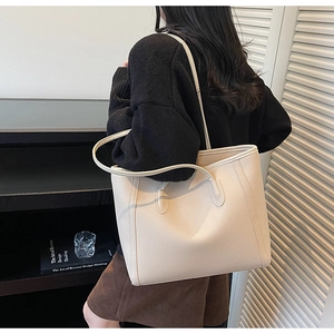 Close-up of a beige lychee pattern tote bag showing high-quality leather texture
