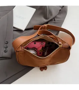 Top view of spacious interior of brown suede crossbody bag with phone and cosmetics
