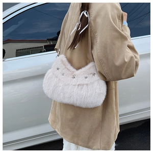 Detail of pink faux fur crossbody bag with silver star studs and metal chain strap