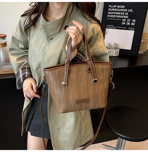 Detail of brown woven texture handbag with leather handle in a cozy cafe setting